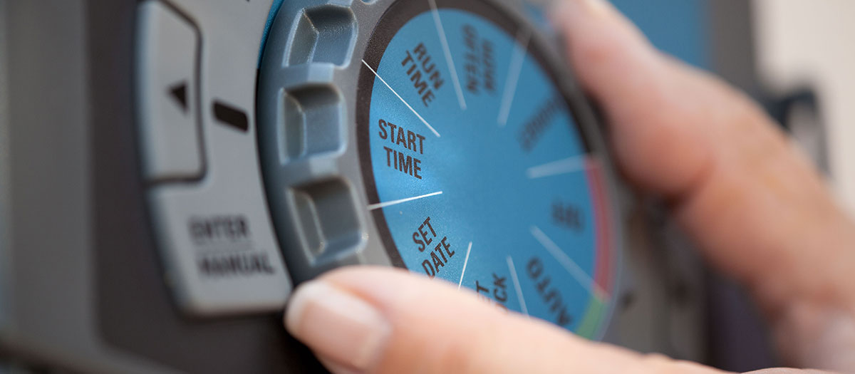 Close up of hand adjusting a irrigation clock