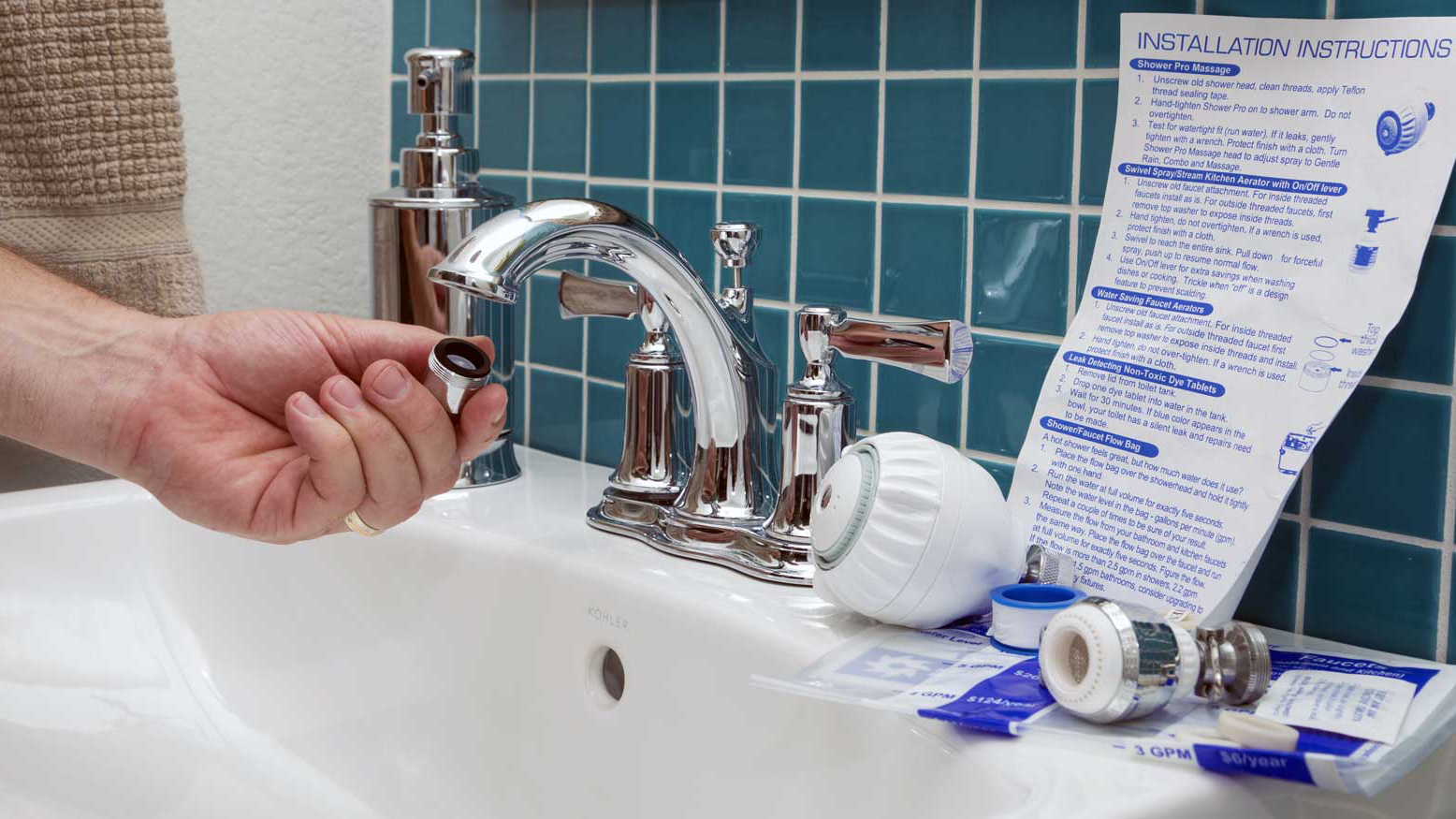 Hand places aerator on faucet